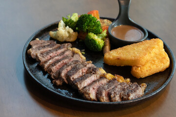 Delicious steak with hash brown, vegetables and sauce.