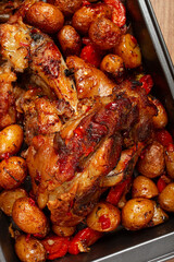 Pork knuckle, baked with vegetables, new potatoes , on a baking sheet, homemade, no people,