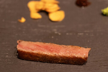 Exquisite gourmet steak presentation on slate.