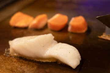 Fresh seafood cooking on a grill surface.