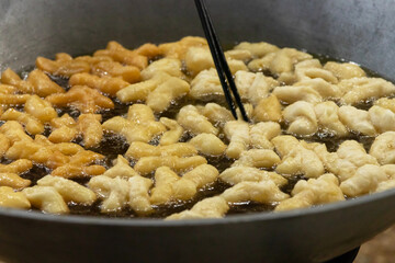 Chinese bread stick or chinese donut deep fry in a pan. Breakfast street food usually eat with hot tea, coffee or soy milk.