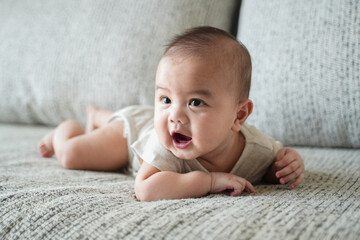 Asian Cute three months old Caucasian baby boy on bed.
