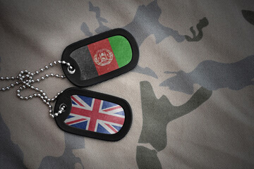 army blank, dog tag with national flag of afghanistan and great britain on the khaki texture...