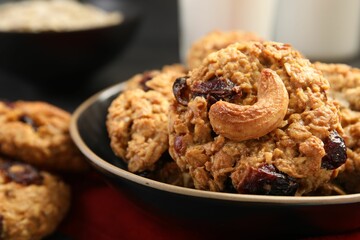 Delicious oatmeal cookies with raisins and nuts on table, closeup