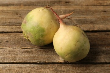 Whole fresh turnips on wooden table, closeup