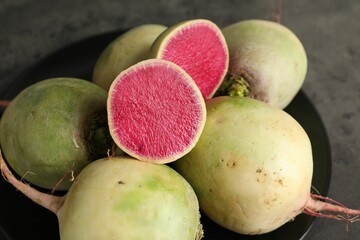 Whole and cut fresh ripe turnips on grey table, closeup