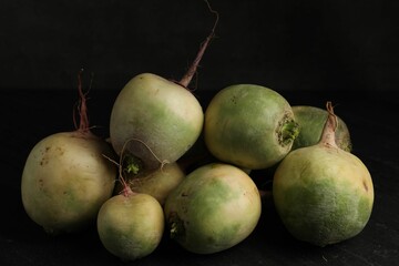 Whole fresh ripe turnips on black table, closeup