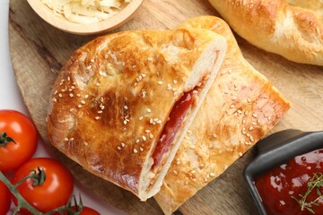 Pieces of fresh calzone pizza served on white wooden table, top view