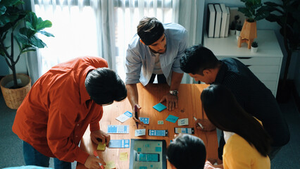 Top down view of team working together to compare and plan UX Ui design. Creative diverse business people in casual cloth discussing about marketing strategy or invest in startup project. Convocation.