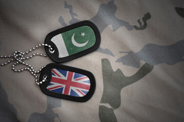 army blank, dog tag with national flag of pakistan and great britain on the khaki texture...