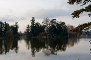Obraz premium View of the rotunda and artificial grotto on Ile de Reuilly at Lake Daumesnil, reflecting tranquility in the Bois de Vincennes landscape