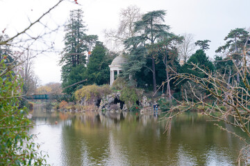 View of the rotunda and artificial grotto on Ile de Reuilly at Lake Daumesnil surrounded by lush greenery