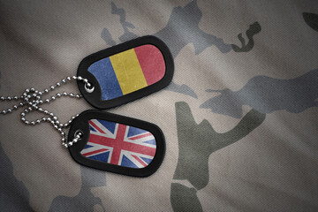 army blank, dog tag with national flag of romania and great britain on the khaki texture...