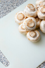 White mushrooms on a silicone cutting board, ready for preparation.
