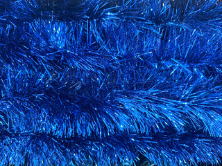 Close up texture of christmas slingers or tinsels in various colors. Made of many materials, tinsels are often used to decorate christmas tree or rooms similar to icicle effects.