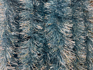 Close up texture of christmas slingers or tinsels in various colors. Made of many materials, tinsels are often used to decorate christmas tree or rooms similar to icicle effects.