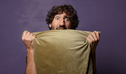 young bearded crazy man hugging a cushion