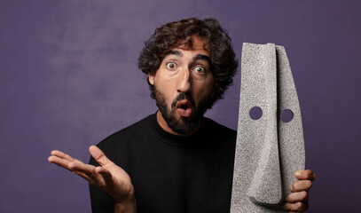 young bearded crazy man with an african mask