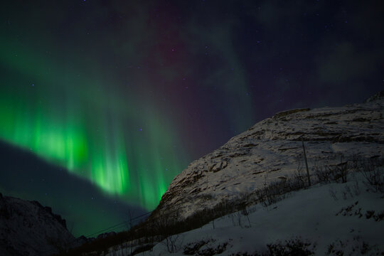 The green lights of the aurora dancing across the sky of Tromso in Norway