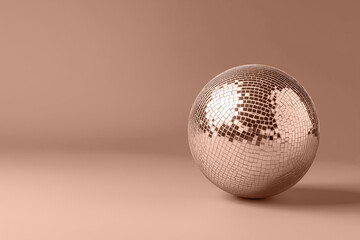 Mocha mousse beige disco ball casts vibrant light in a minimalist space. Modern trendy tone hue shade