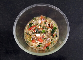 Baigan ka Bharta an indian food dish served in a transparent bowl of glass