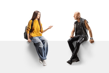 Naklejka premium Female teenager sitting on a panel and talking to a bald punk man