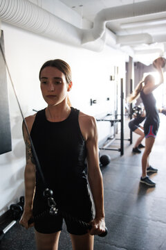 Focused Individuals Engaging In Intense Gym Workout Together