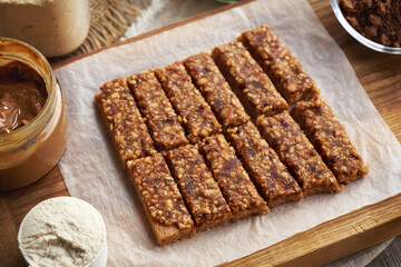 Homemade no-bake healthy bars made of whey protein powder, maple syrup, peanut butter and medjool dates