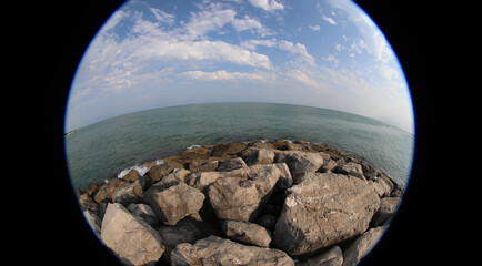 Fisheye lens view of a marine environment with sea and the black outline caused by the special type of photographic lens that creates a vision effect like through a telescope