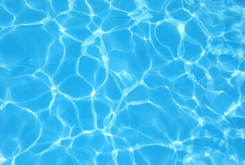 background of the turquoise blue pool water with light reflections and no other people