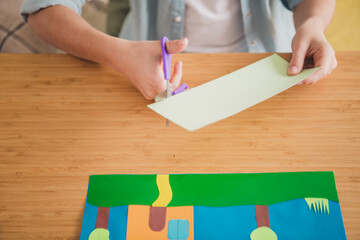 Young girl engaged in creative paper cutting indoors with bright colors