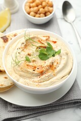 Delicious hummus with paprika, pita and chickpeas on table, closeup