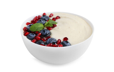 Tasty cooked semolina porridge with blueberries, pomegranate and mint isolated on white