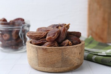 Tasty dried dates on white tiled table, closeup