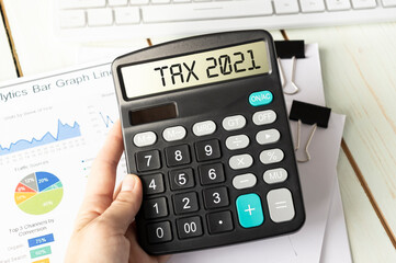 Word TAX 2021 on calculator. Business and finance concept.