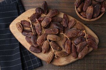 Tasty dried dates on wooden table, top view