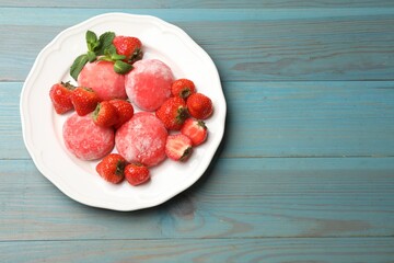 Delicious mochi, strawberries and mint on light blue wooden table, top view. Space for text