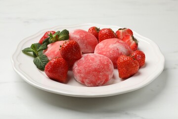 Delicious mochi, strawberries and mint on white marble table, closeup