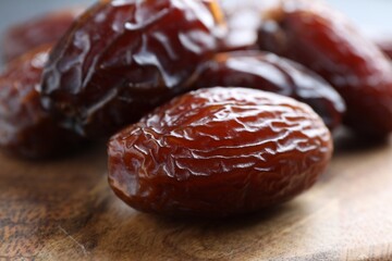 Tasty dried dates on wooden board, closeup