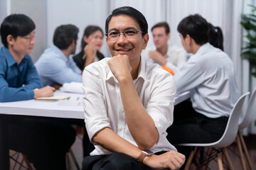 Engineer team leader portrait with diverse group of civil engineer and client working together on architectural project, reviewing construction plan and building blueprint at meeting table. Prudent