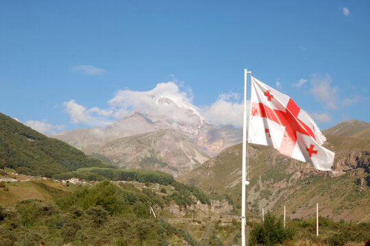Georgian flag against the backdrop of Mount Kazbek