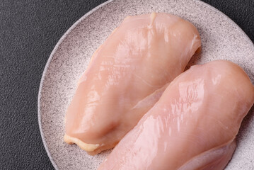 Fototapeta premium Pieces of raw chicken or turkey fillet with salt, spices and herbs