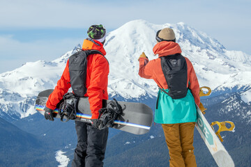 2 snowboarders viewing mountain