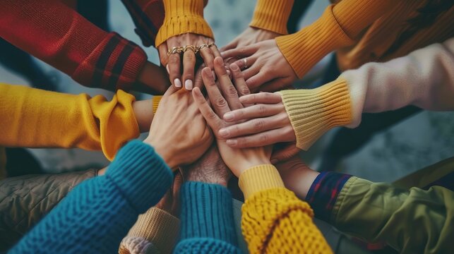 Diverse group of hands joining together in a colorful display of unity and collaboration.