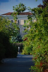 Hinter einem grünen Park steht ein Haus, halb versteckt.