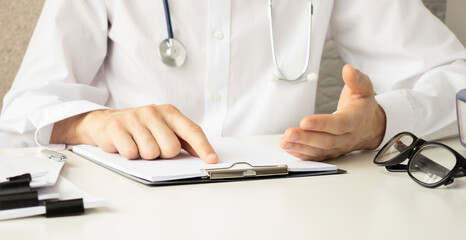 Fototapeta premium Medicine doctor's working on desk. Closeup of Stethoscope. Physician man video call raise hands explain patient understand on table front computer monitor at hospital office, Healthcare medic concept