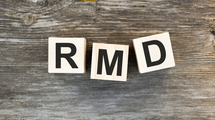 The abbreviation RMD is made from wooden building blocks on a gray wooden background.