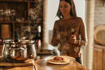 Couple cooking together in a bright kitchen, smiling as they prepare fresh pasta with sunlight streaming in