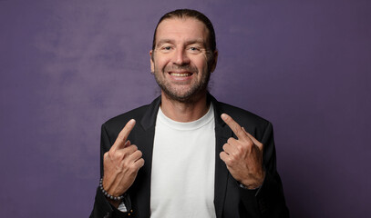 smiling confidently pointing to own broad smile, positive, relaxed, satisfied attitude