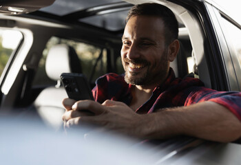 Man driving car and using phone